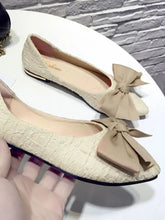 Two pairs of cream point toe flats with large beige bows