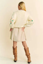 Cream knit cardigan with Dani floral pattern, puff sleeves, and button closure