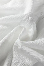 White textured cotton button down loose shirt with crinkled texture and subtle lantern sleeve button closure