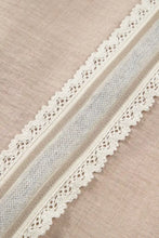 Cream-colored lace trim with intricate floral patterns on pullover rolled short sleeve blouse edge