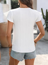 White pleated short-sleeved neck blouse with crochet trim and ruffled shoulders in a trim v neck design
