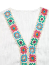 White textured neck blouse featuring a colorful crochet trim v neck with pink teal and orange square patterns
