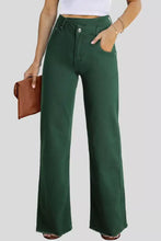 Dark green high-waisted flared denim jeans with straight leg cut and raw hem featuring crossed waist detail