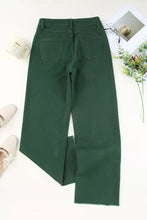 Dark green denim crossed waist raw hem wide-leg jeans with straight hem and back pockets shown from the back side