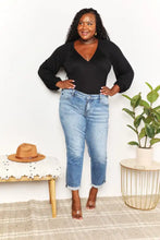 A pair of light-wash straight-leg denim jeans with rolled cuffs paired with culture code full size long sleeves neck bodysuit