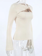 Cream-colored long sleeve top with a cutout knot front twist neckline and bell sleeves for stylish wear
