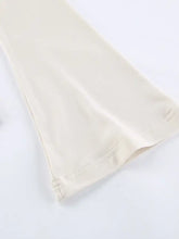 Cream-colored smooth fabric long sleeve with neatly stitched hem detail for cutout knot front top