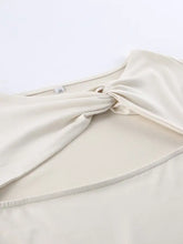 Cream-colored soft fabric long sleeve top with cutout knot front detail and knotted neckline design