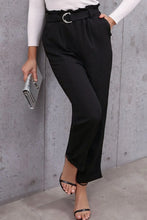 Black high-waisted belted paperbag waist pants with wide belt and silver circular buckle for a stylish fit