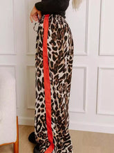 Leopard print wide leg pants with bold red side stripe designed for stylish comfort and modern wear
