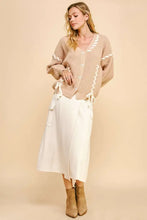 Beige chunky knit cardigan with lace-up ribbon bow and textured braids