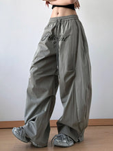 Gray drawstring oversized wide leg casual pants with pretty girl embroidered in black script on the thigh