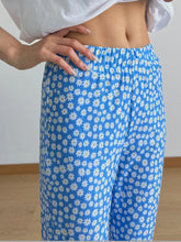 Blue floral print flare leg pants with white daisy pattern and elastic waistband for comfortable wear