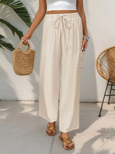 Cream-colored drawstring wide leg pants with loose fit and subtle texture suitable for machine wash cold care