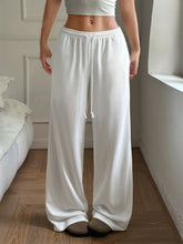 White relaxed wide leg sweatpants with elastic waistband and matching drawstring for comfortable wear