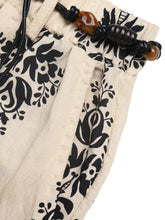 Beige cotton boho print wide leg pants with black floral embroidery and amber bead drawstring detail