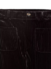 Black high-waisted wide-leg pants in corduroy with subtle sheen, two front pockets, and metallic button fastening