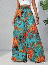 Tropical print wide-leg pants in teal orange and brown tones featuring a vibrant tropical print design