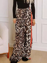 Leopard print wide leg pants featuring a side orange stripe for a bold and stylish look