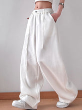 White loose-fitting wide leg pants with elastic waistband and side pockets for comfortable casual wear