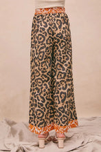 Bi bi leopard print wide-leg pants in beige and black with orange floral elastic waistband and ruffled hem