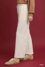 Cream-colored umgee cable knit textured wide leg pants with drawstring waist and flared legs
