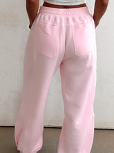 Back view of pink casual drawstring sweatpants with elastic waistband and two pockets machine wash care instructions