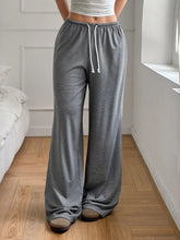 Gray drawstring wide leg pants with ribbed texture and white drawstrings made of comfortable fabric