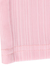 A soft pink ribbed fabric with subtle texture and stitched hem on tied wide leg pants showing wide leg design
