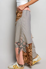 Patchwork wide-leg pants in striped floral and solid pink fabrics with ruffled hems and partial elastic with big star patch
