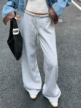 Gray wide leg drawstring sweatpants with a drawstring waistband and loose comfortable wide legs for casual wear