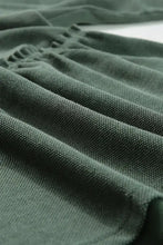 Olive green long sleeve peplum top with textured ruffles and V neck