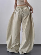 Beige oversized baggy wide leg drawstring pants with elastic waistband and flowing voluminous silhouette