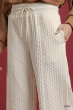 Cream-colored umgee wide leg pants with cable knit texture and elastic waistband with matching drawstrings