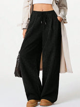 Black corduroy wide-leg pants with elastic waist and drawstring designed for comfort and easy machine wash care instructions