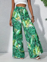 Printed high waist wide leg pants featuring green and white tropical leaf print for a stylish summer look