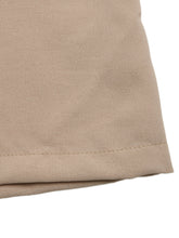 Beige fabric with subtle woven texture and stitched hem on smocked waist wide leg pants for comfortable wear