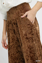 Brown umgee velvet smocked waistband wide leg pants with a textured mottled pattern and elastic smocked waistband