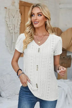 Woman in decorative button eyelet V-neck short sleeve T-shirt with blue jeans