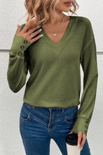 Olive green waffle knit V-neck top with long sleeve and decorative button cuffs