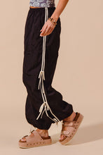 Black loose fit jogger pants with white drawstring ties and double lined side detail for casual wear