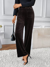 High-waisted wide-leg pants in black velvet with vertical ribbed texture and front pockets for elegant wear