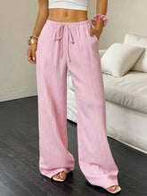 Pink tied wide leg pants with drawstring waist and subtle vertical pleats in soft fabric for casual wear