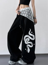 Black wide leg drawstring pants with bold white snake graphic star accents and sheer lace trim at the waistband
