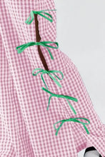 Pink and white checkered cotton apron with green laces and accents