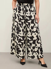 Plus size abstract print wide-leg pants in black and white geometric pattern with drawstring waistband for comfort