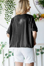 Woman in distressed asymmetric hem cropped tee shirt with paint splatters