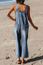 Distressed bib pocket wide leg denim overalls on woman