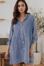 A light-wash denim dress with distressed collared neck, button-front, relaxed fit, and collared neck flounce sleeves