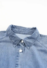 Light blue denim dress with distressed collared neck and silver-toned buttons featuring a classic collared neck flounce